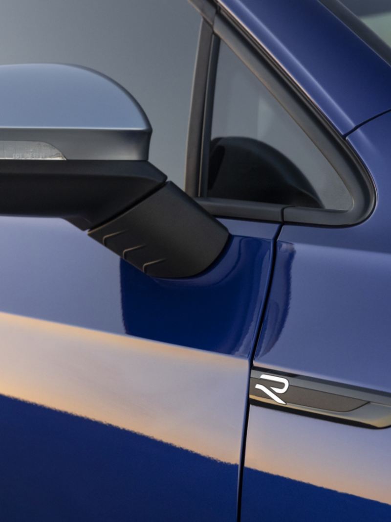 A close-up of the blue 2024 Golf R mirror caps and grille with signature blue R accents on it.