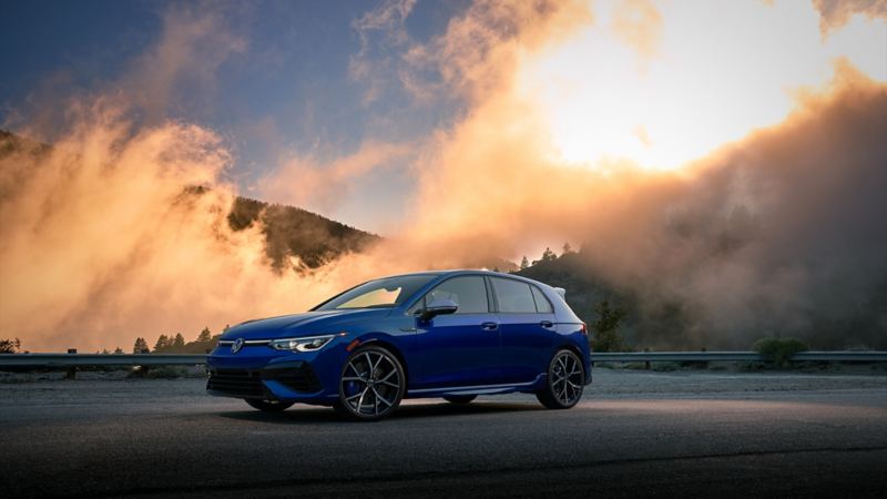 The 2023 Volkswagen Golf R is on a road while fog is coming down the hill