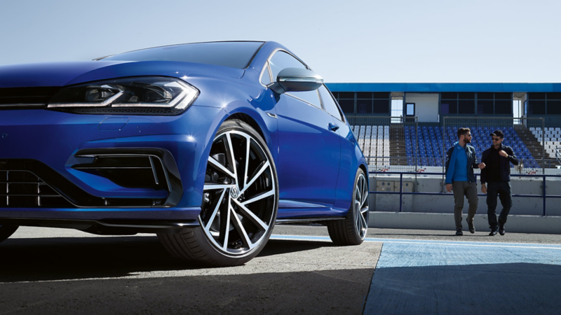 Close-up of the 18 inch Cadiz alloy wheel of the Volkswagen Golf R MK7 painted in Lapis Blue Metallic parked on a racetrack