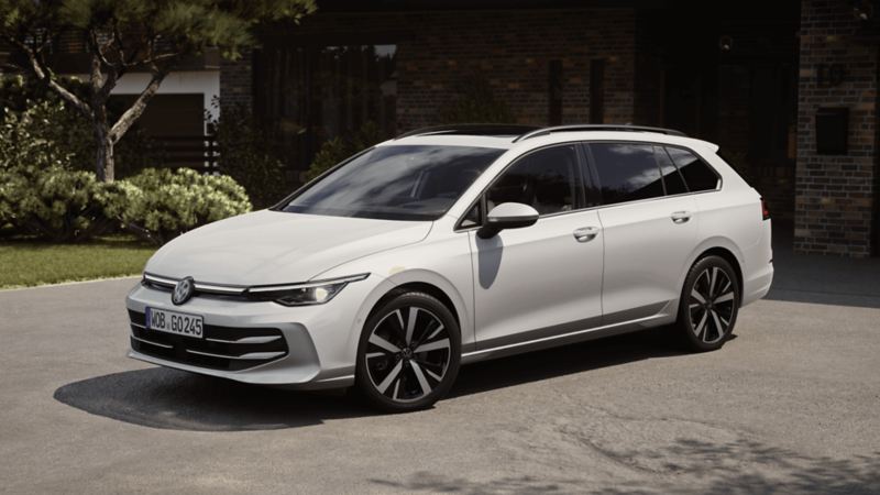 Biały Volkswagen Golf Variant zaparkowany przed domem