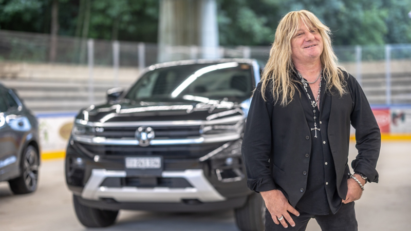 Leo Leoni steht lächelnd vor seinem VW.