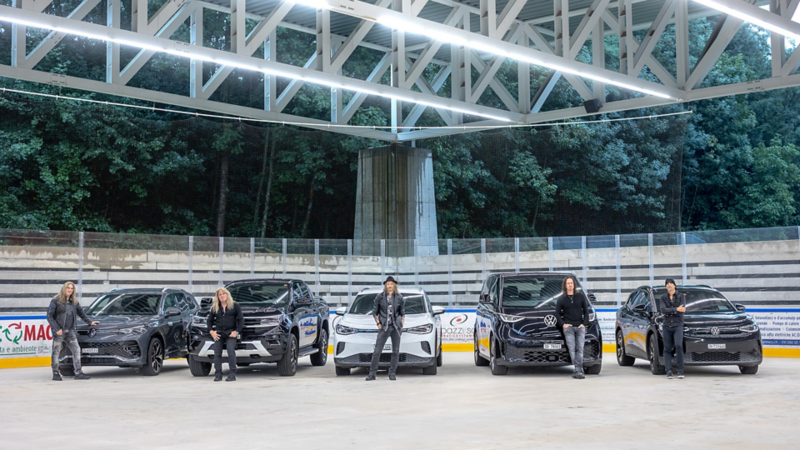 Die Band Gotthard steht in der Eishalle vor ihren VW Modellen.