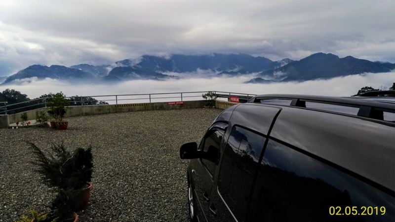 漠地棕色Caddy Maxi車身反射遠方群山及雲海景