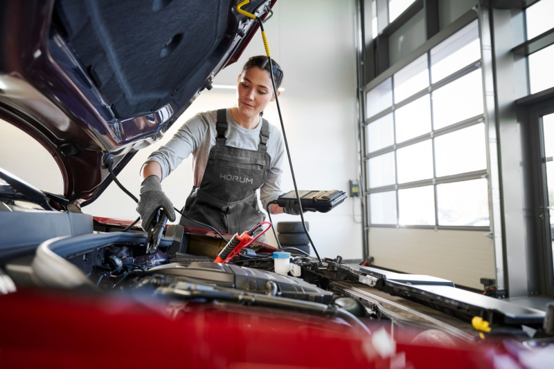Mechanik HORUM wykonuje diagnostykę silnika w czerwonym samochodzie Volkswagen