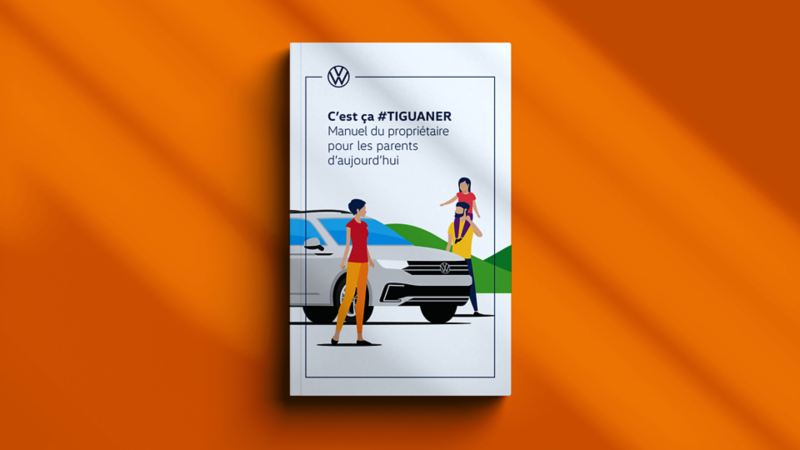 Le manuel « C’est ça #TIGUANER » est fermé et déposé sur un fond orange. La couverture du manuel représente un dessin d'une famille à côté d'un Tiguan 2022 avec le titre : C’est ça #TIGUANER Manuel du propriétaire pour les parents d’aujourd’hui.