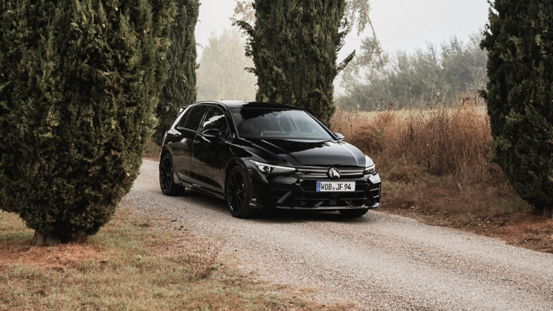 A man standing next to a Volkswagen Golf-R