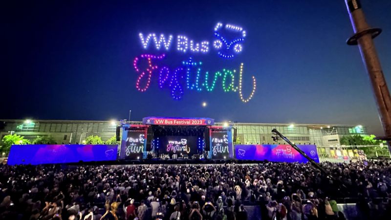 Drones create the VW Bus Festival logo above the concert venue.