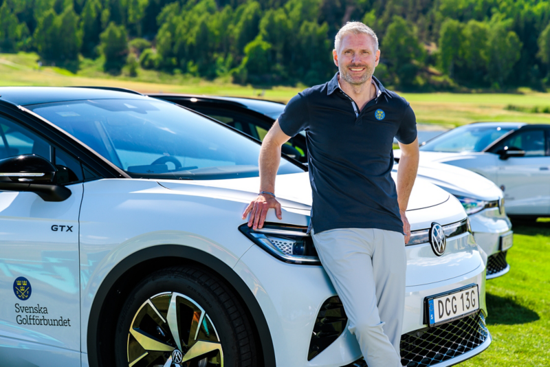 Anders Dalered står lutad mot en vit Volkswagen ID. 4