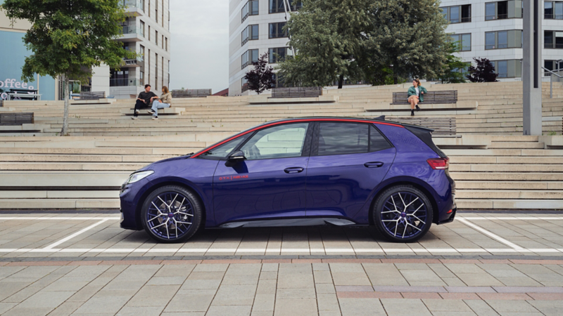 La Lila ID.3 Fire & Ice est garée sur une place publique. On aperçoit de grands bâtiments en arrière-plan.