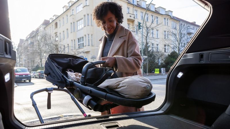 Jeniffer Mulinde Schmid range sa poussette dans le coffre de sa voiture