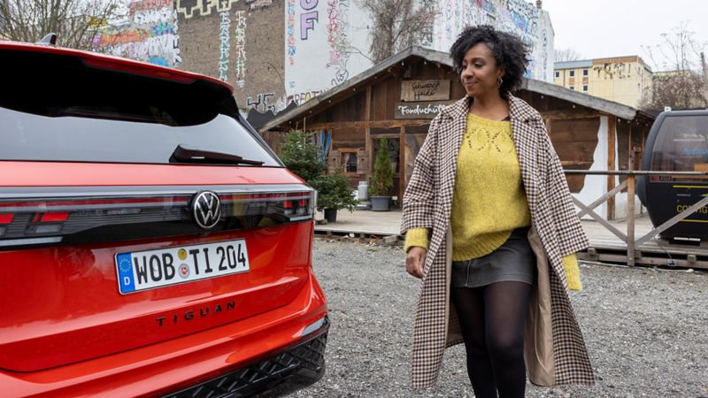 Jeniffer Mulinde Schmid se tient à côté de son Tiguan