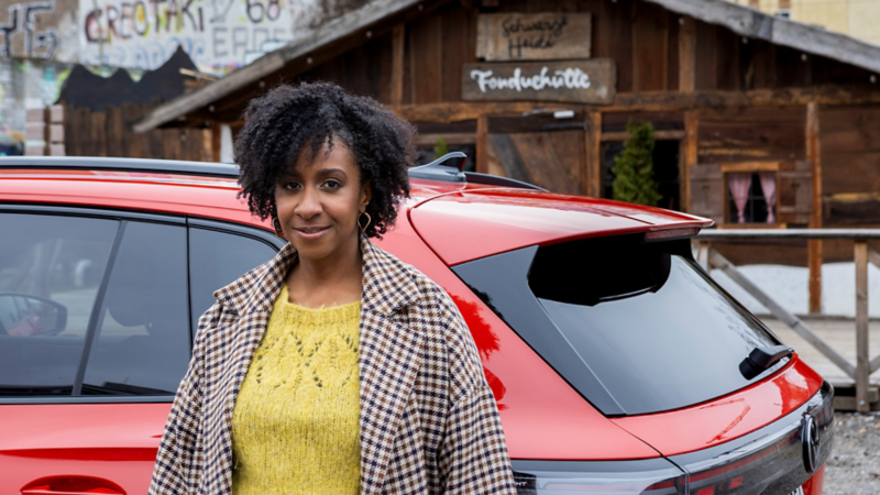 Jeniffer Mulinde Schmid steht vor ihrem Tiguan