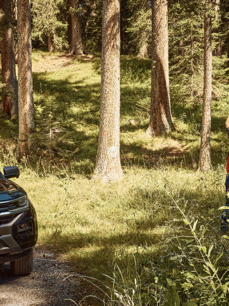VW Amarok garé dans la forêt et, à côté, trois gardes forestiers qui discutent de quelque chose