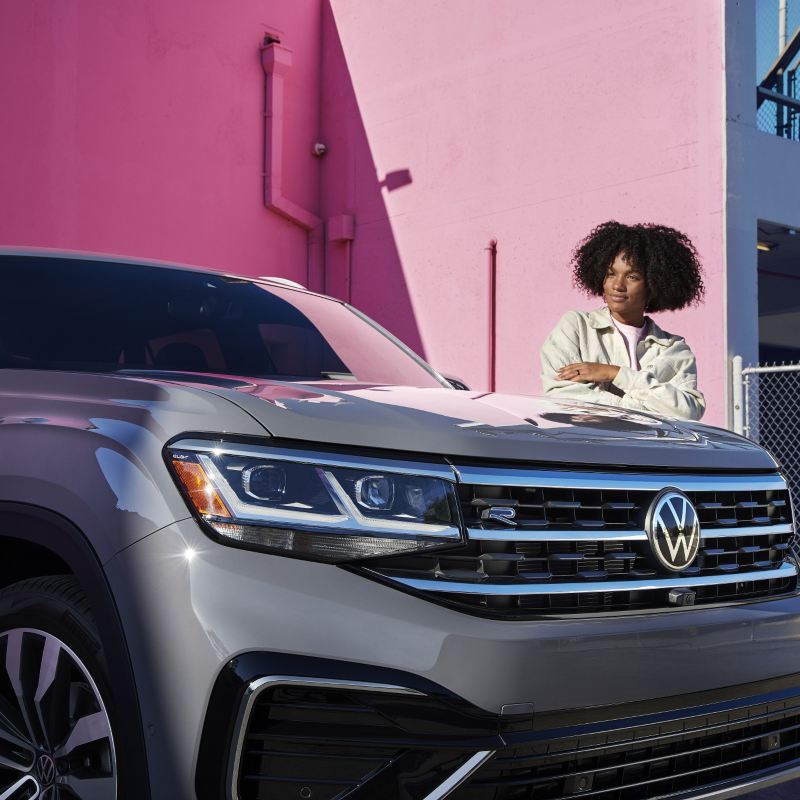 Woman standing in front of VW Atlas Cross Sport SUV