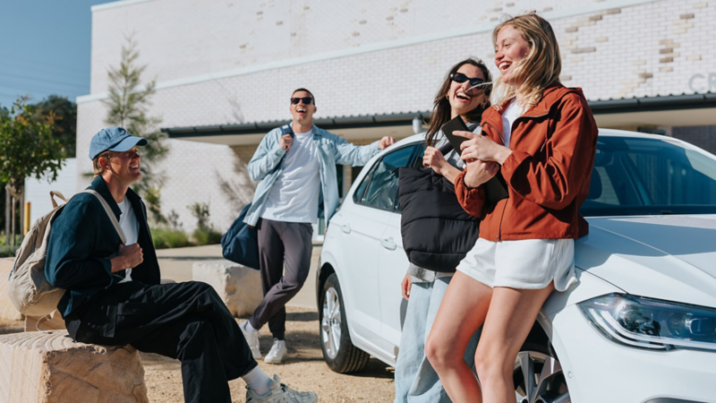 Volkswagen New POLO parked beside wall with a girl seeing across the road and boy standing near the passenger door