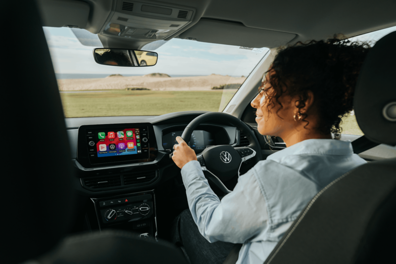 Woman driving T-cross at beach