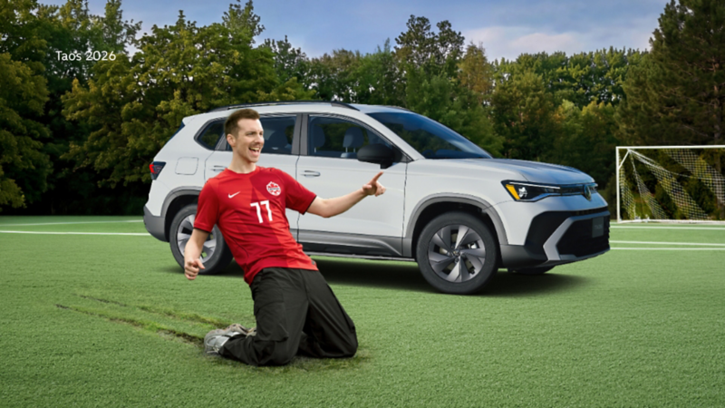 Pier-Luc Funk, vêtu d’un maillot de Canada Soccer, célèbre à genoux sur un terrain de soccer devant un Volkswagen Taos 2026.