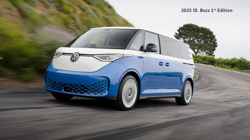 A Candy White/Cabana Blue Metallic ID. Buzz 1st Edition 4MOTION drives on a winding mountain road, surrounded by greenery and trees, with motion blur emphasizing its speed and agility.