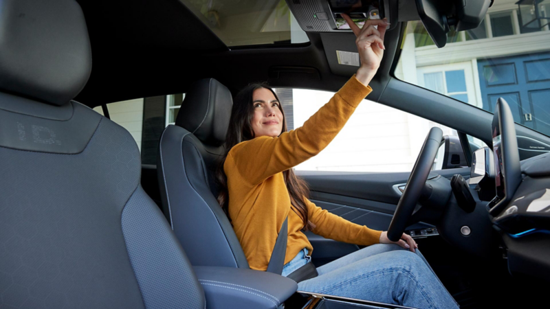Une Volkswagen Jetta Blanc Oryx Nacré roule sur une autoroute à l'aube, avec un ciel bleu et rose au-dessus d'un paysage plat et brun.