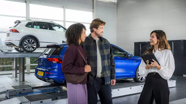 Volkswagen servicemedewerker laat iets zien aan klant op tablet, ze staan binnen bij de receptie