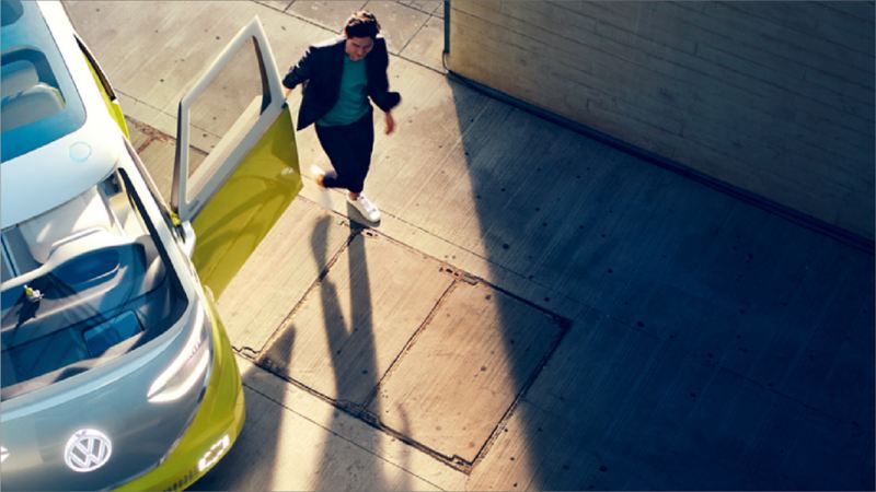 Une femme debout à côté d’un véhicule électrique