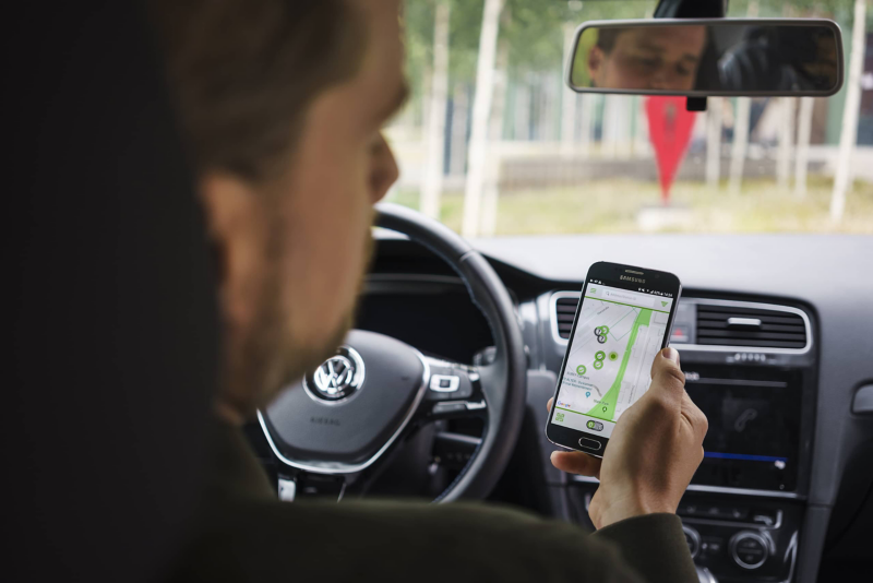 The smartphone shows the next charging station