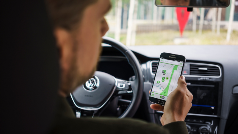 The smartphone shows the next charging station
