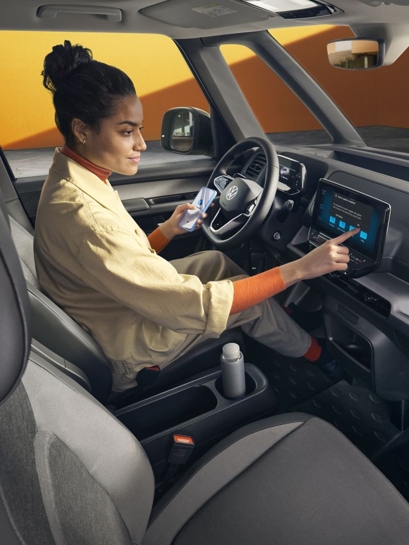 Donna al volante connette lo smartphone al touch screen del veicolo. 