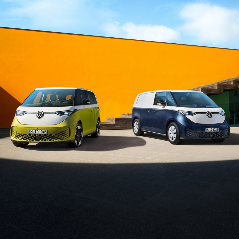 Der VW ID. Buzz und ID. Buzz Cargo Parken vor einer Orangen Wand.