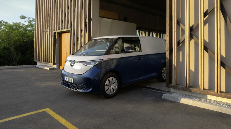 Tvåtonslackerade elskåpbilen VW ID. Buzz Cargo på väg ut ur ett garage