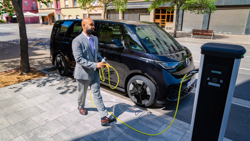 Ein Mann entfernt das Ladekabel an seinem VW ID. Buzz.