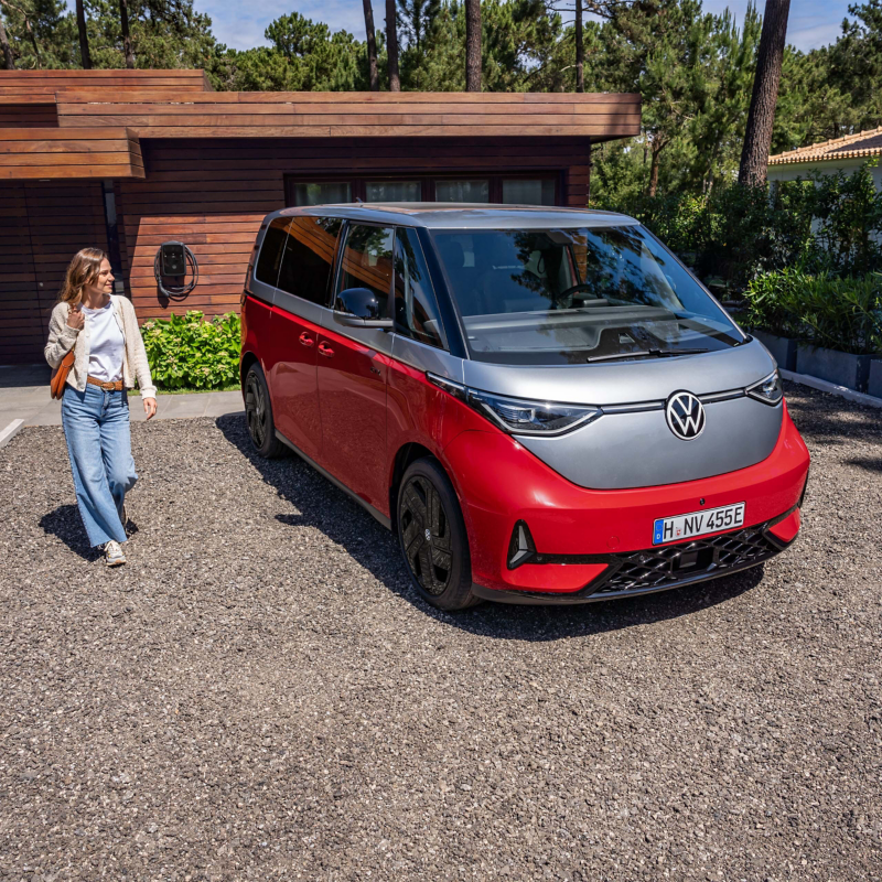 VW ID. Buzz parkt auf einer Auffahrt, im Hintergrund der ID. Charger 2.