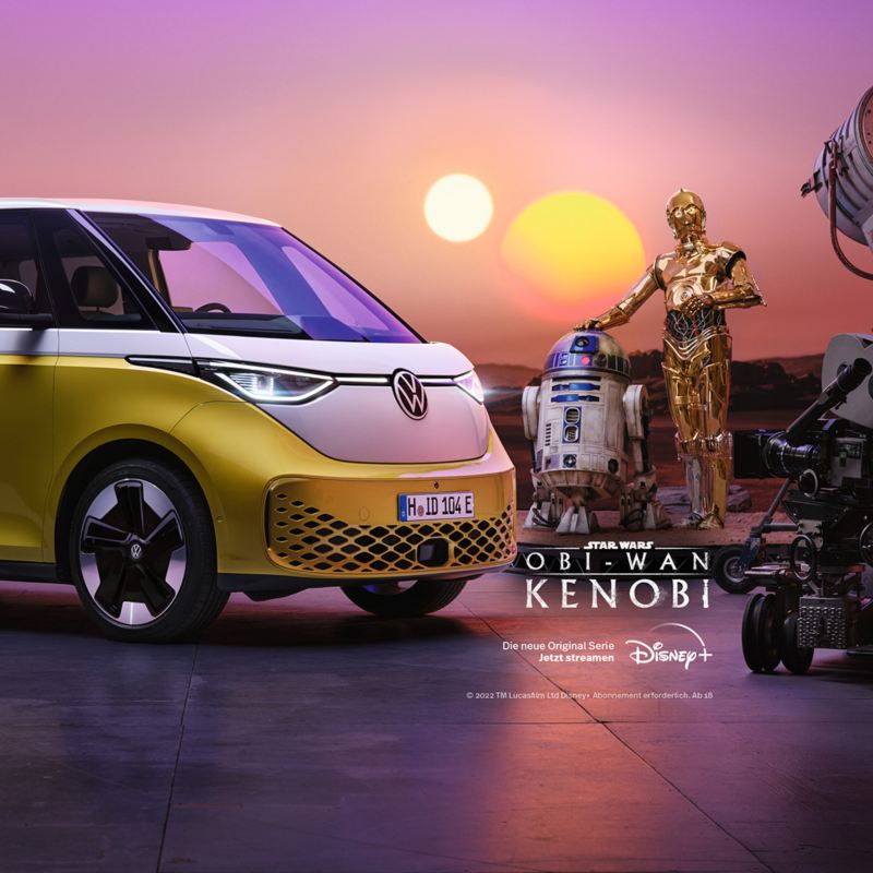 Seitenansicht eines weiß-gelben VW ID. Buzz, der scheinbar auf einem fremden Planeten parkt und Strom lädt. Die Star Wars Droiden R2-D2 und C-3PO schauen dabei zu.