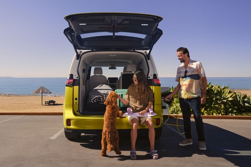 L’ID. Buzz VW garé sur une plage avec le hayon ouvert. 