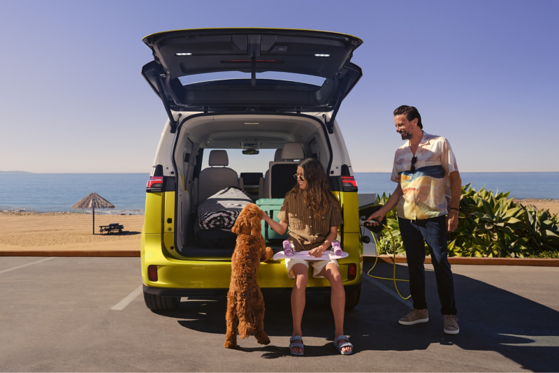 A man connects a charging cable to the VW ID. Buzz.