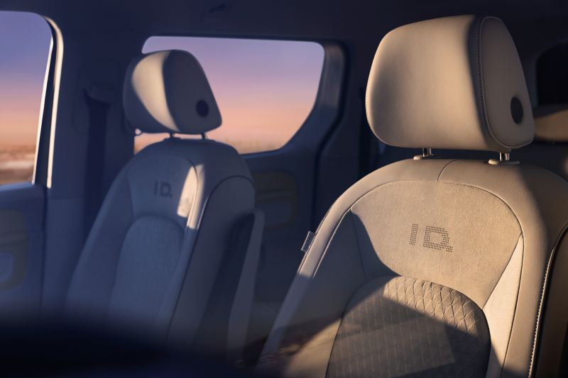 Seitlicher Blick auf die vordere Sitzreihe des VW ID. Buzz bei Sonnenuntergang. 