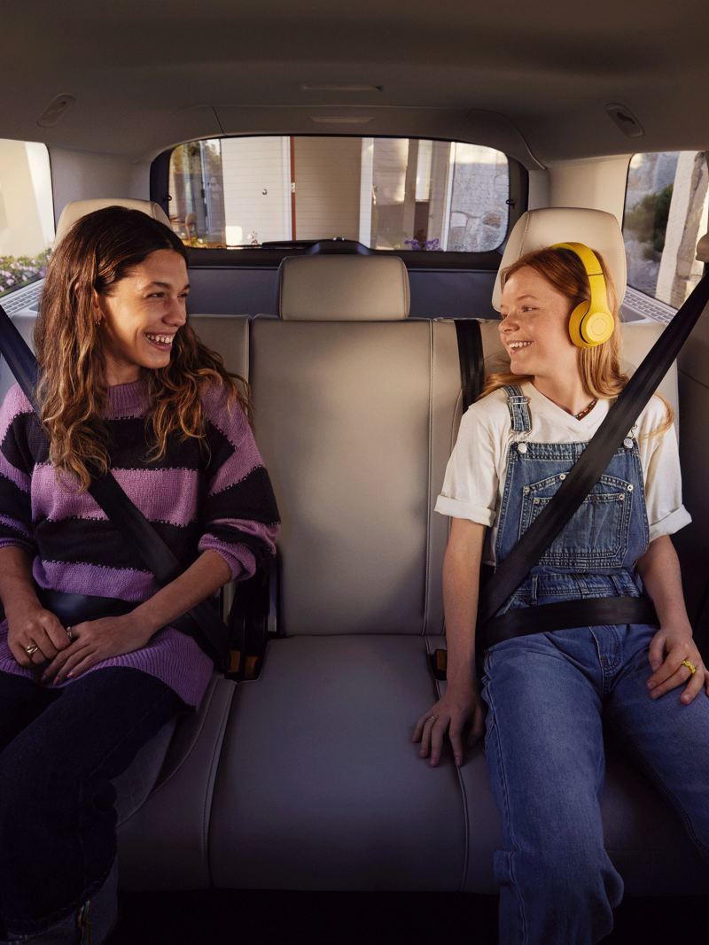 Deux jeunes filles sont assises sur la banquette arrière de l’ID. Buzz VW.