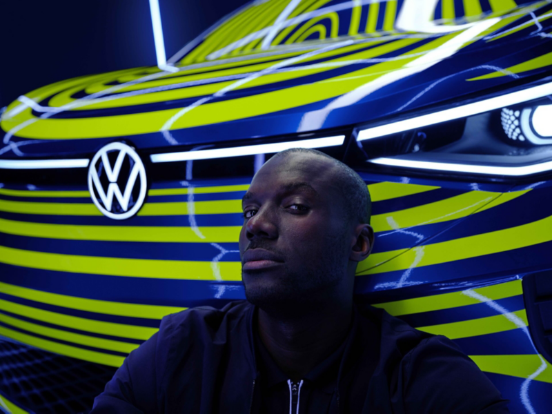 Man leunt tegen de grille vooraan van de VW ID.4