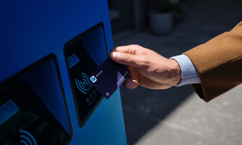 Un homme approche sa carte We Charge d'une borne de recharge dédiée.