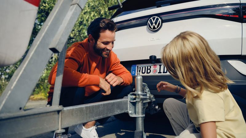 A VW service employee carries out an inspection on a VW electric vehicle