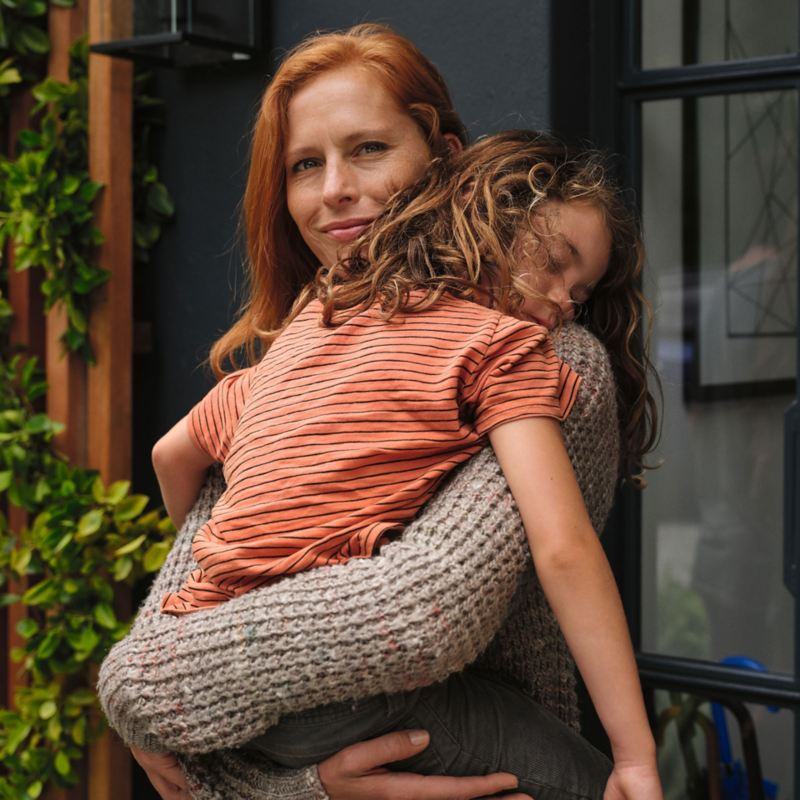 Frau mit schlafender Tochter auf dem Arm