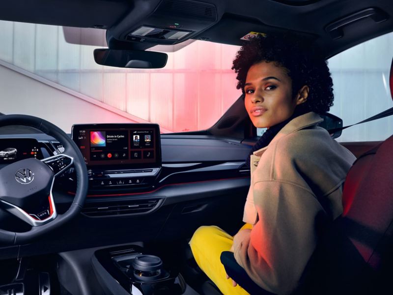 VW ID.4 GTX kupé med blikk på forsete og førerplass. En kvinne sitter på passasjersete foran og ser bakover.
