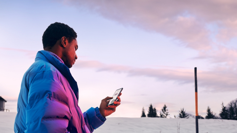 Gros plan d’un homme tenant un smartphone à deux mains. L’application We Connect ID. est visible sur l’écran. 