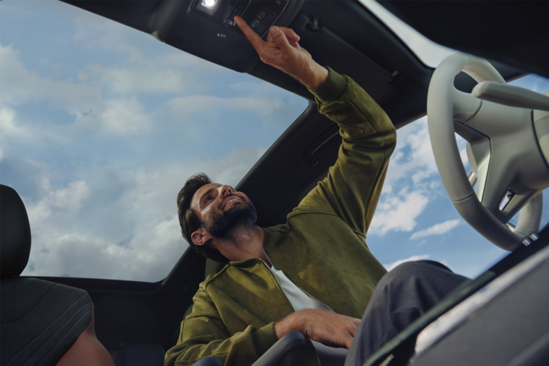 Un uomo all'interno dell'auto, sullo sfondo il tettuccio a vetri.