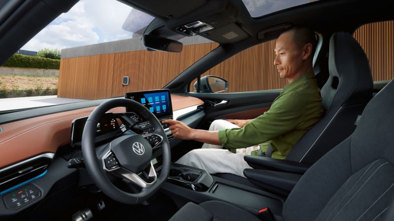 Vy i cockpiten på en VW ID.5. En man sitter i passagerarsätet och använder infotainmentsystemet