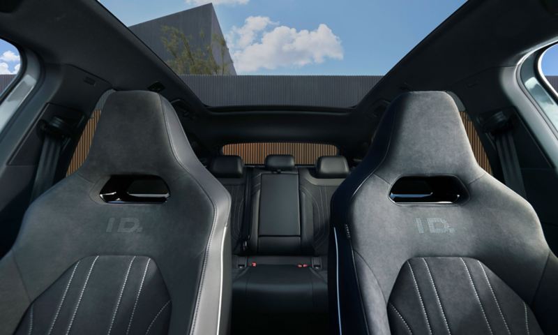 Άποψη στο εσωτερικό ενός VW ID.5, από μπροστά στην πανοραμική γυάλινη οροφή, στα μπροστινά καθίσματα και στο πίσω μέρος.
