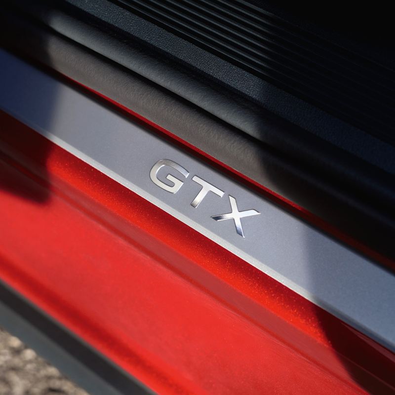 Ein GTX Schriftzug steht in der Fahrertür eines VW ID.5 GTX in Kings Red Metallic.