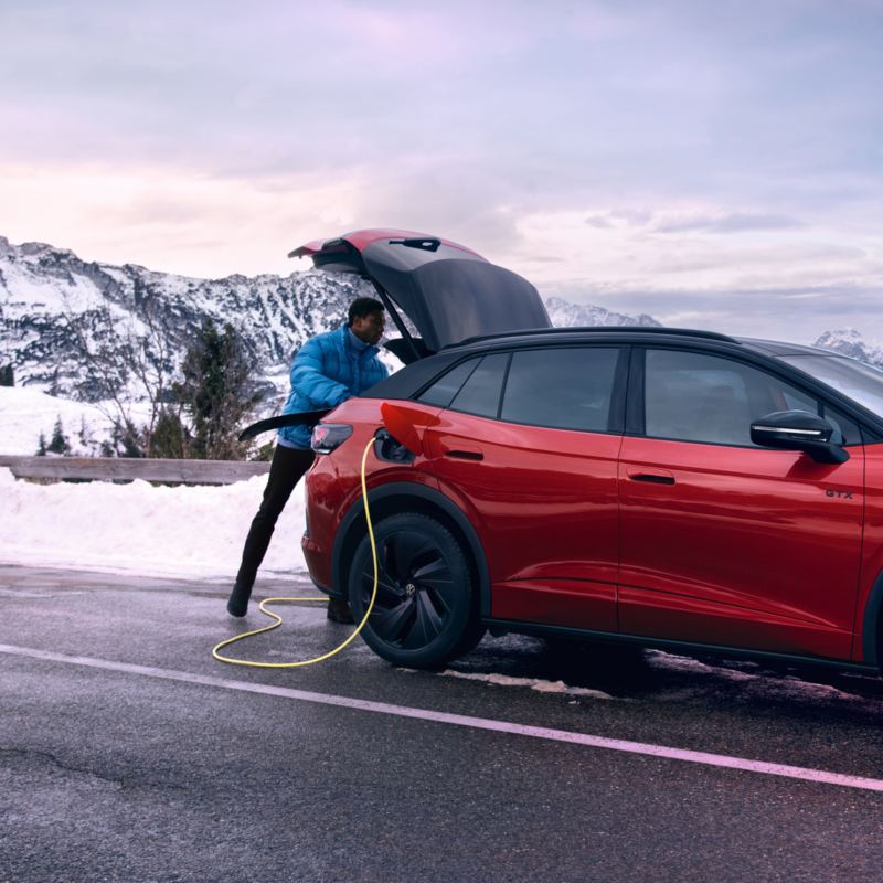 Ein roter VW ID.4 GTX steht in den Bergen.