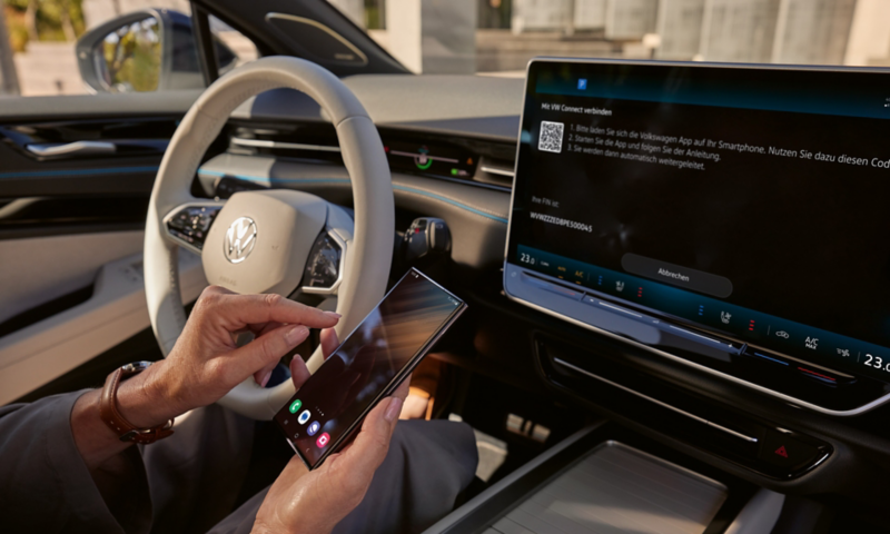 Interiøret i vw id7 fastback. En smarttelefon kobles til infotainmentsystemet 