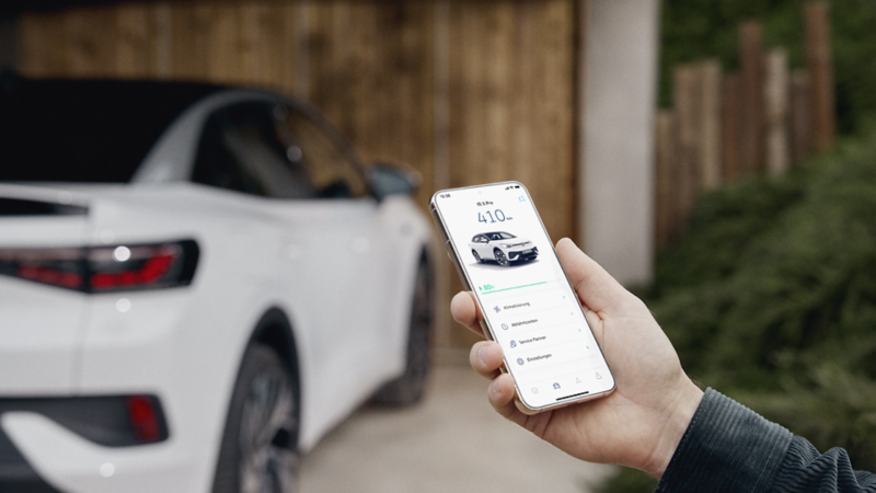 A person uses their phone in front of an VW ID.5